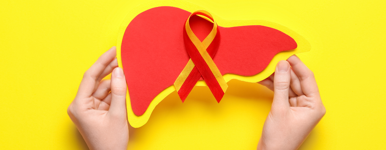Fígado em papel colorido com laço vermelho e amarelo ao centro, julho amarelo. Mês dedicado à prevenção combate à hepatite.