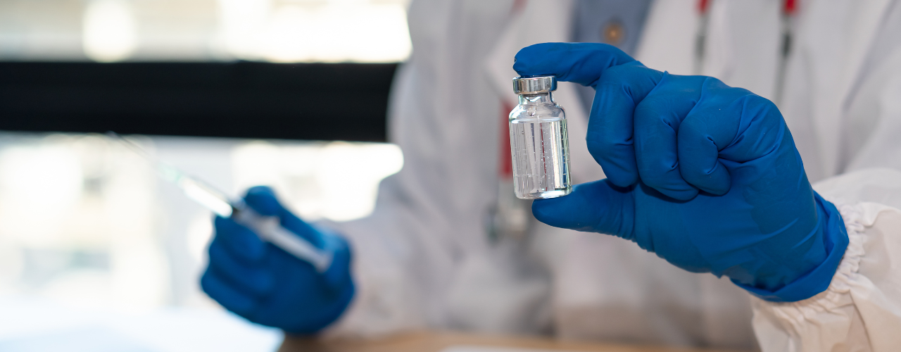 Profissional da saúde usando luvas azuis segurando um vidro de dexametasona