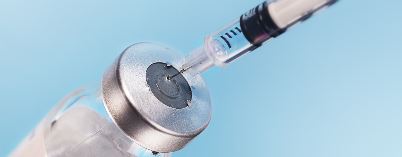 imagem de seringa pegando medicamento injetável deslanosídeo do vidro com fundo azul