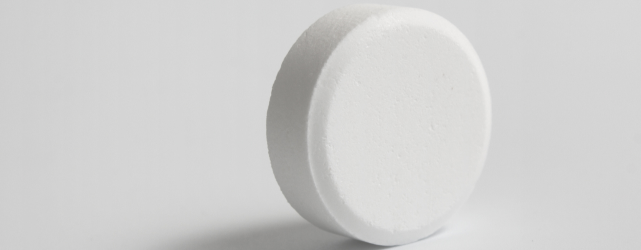 Imagem de um comprimido branco de metadona unitário em fundo branco.